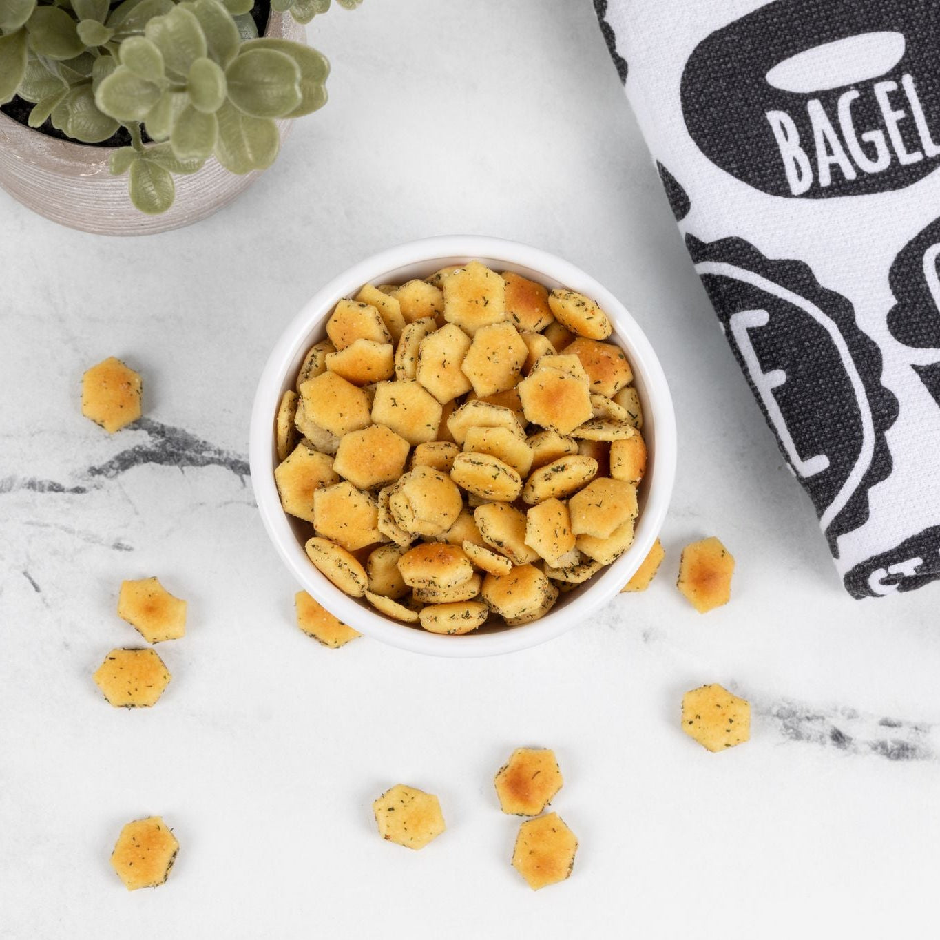 Small bowl of snacks on a marble surface with a kitchen towel in the background